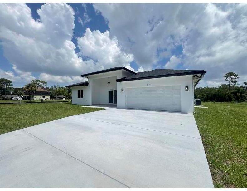 A white, single-story house with a black roof and a large concrete driveway — 13177 47th Court N, FL 33411, FL