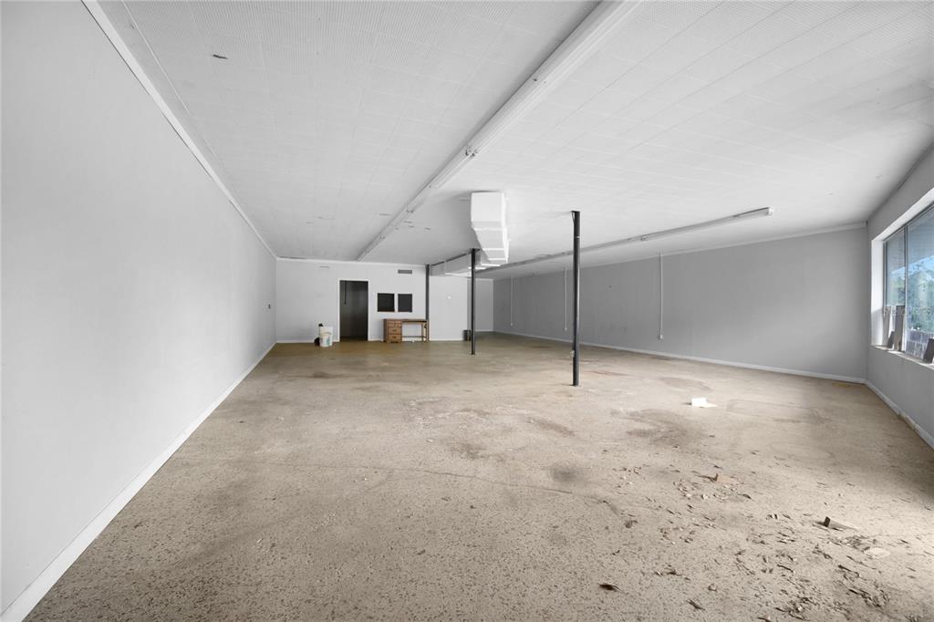 An empty commercial space with a concrete floor, white walls, and a drop ceiling — 5818 SAINT AUGUSTINE ROAD, JACKSONVILLE, FL