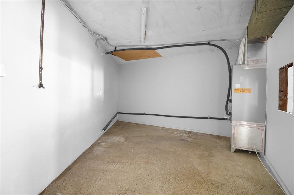 An unfinished utility room features concrete flooring, white walls, and an exposed HVAC unit — 5818 SAINT AUGUSTINE ROAD, JACKSONVILLE, FL