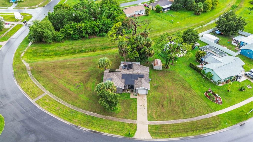 An aerial view shows a single-story house with solar panels on a large corner lot — 5409 KENWOOD DRIVE, NORTH PORT, FL