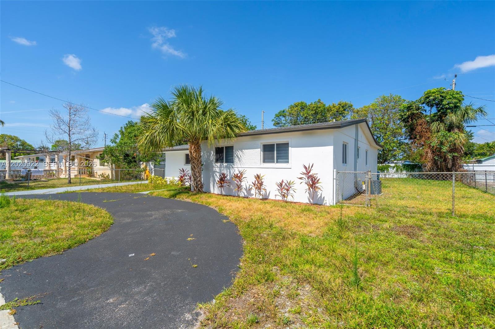 A white single-story house features a curved asphalt driveway and a palm tree — 17231 NW 24th Pl, Miami Gardens FL 33056, MIAMI GARDENS, FL