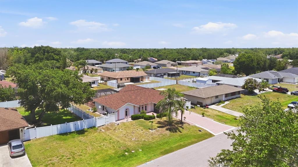 An aerial view shows a residential neighborhood with single-story houses, fenced yards, and paved driveways — 21452 BANCROFT AVENUE, PORT CHARLOTTE, FL