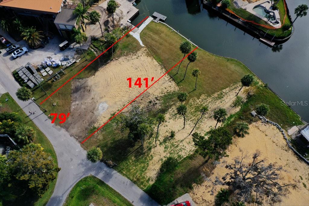 An aerial view shows a vacant, sandy waterfront lot marked with red boundary lines — 1845 SE 3RD COURT, CRYSTAL RIVER, FL