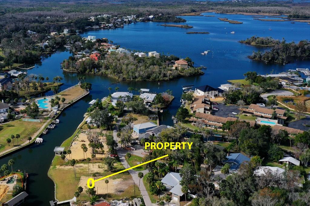 An aerial view shows a vacant waterfront lot with a yellow marker indicating the property — 1845 SE 3RD COURT, CRYSTAL RIVER, FL