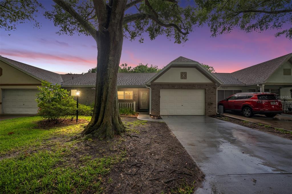 A single-story house with a large tree in the front yard and a red car — 9382 SW 89TH COURT ROAD UNIT C, OCALA, FL
