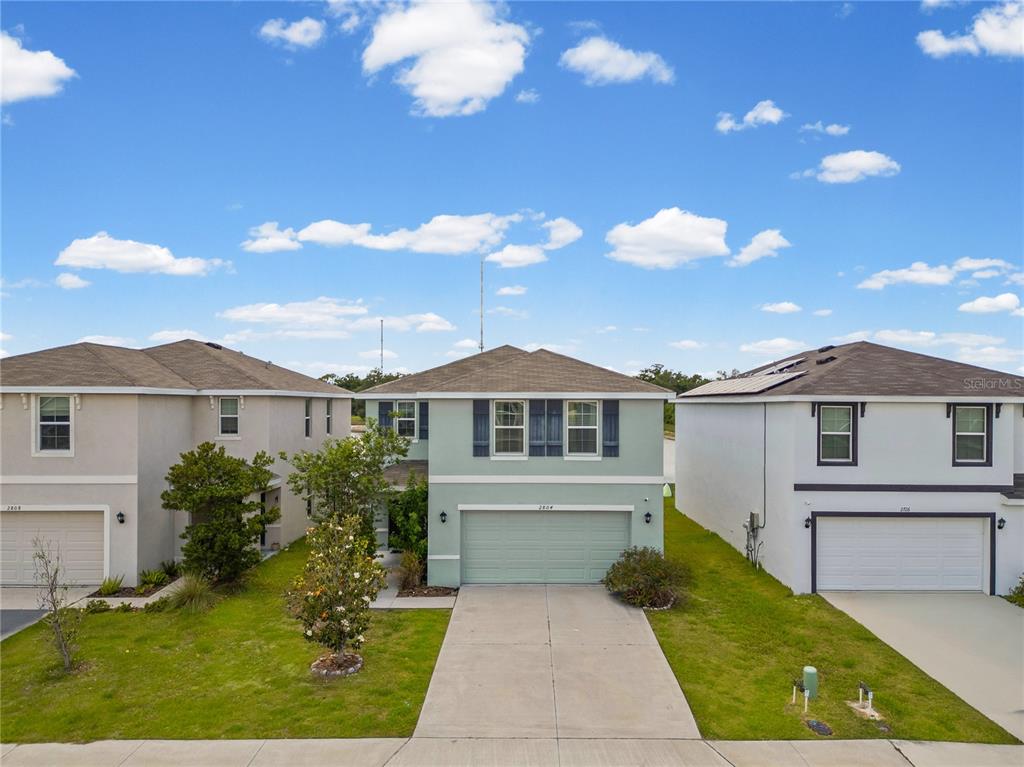 A two-story light green house with a two-car garage sits between two neighboring homes — 2804 ROCK SOUND STREET, BRADENTON, FL