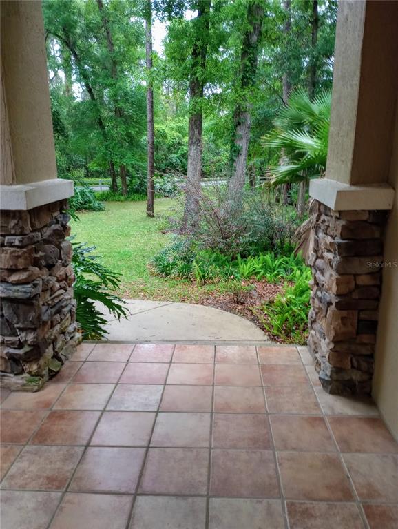 A covered entryway features tile flooring, a white front door, and a light fixture — 4280 SE 26TH TERRACE ROAD, OCALA, FL
