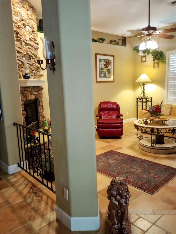 A tiled porch with stone-clad columns overlooks a grassy yard and wooded area — 4280 SE 26TH TERRACE ROAD, OCALA, FL