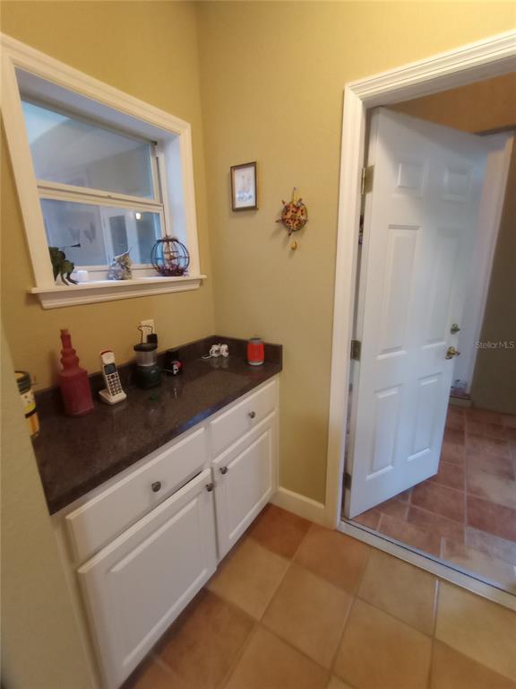 A living room features a stone fireplace, a red recliner, and a round coffee table — 4280 SE 26TH TERRACE ROAD, OCALA, FL