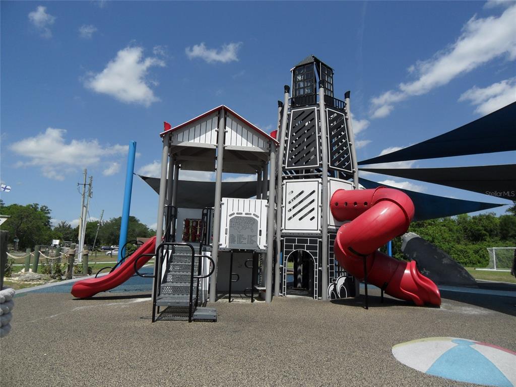 A playground structure features a lighthouse-themed tower with red slides and a shaded seating area — 276 SAN GABRIEL STREET, WINTER SPRINGS, FL