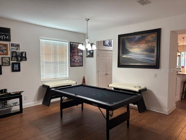 A game room features a pool table, two benches, and a large framed landscape painting — 9819 ROYAL VISTA AVENUE, CLERMONT, FL
