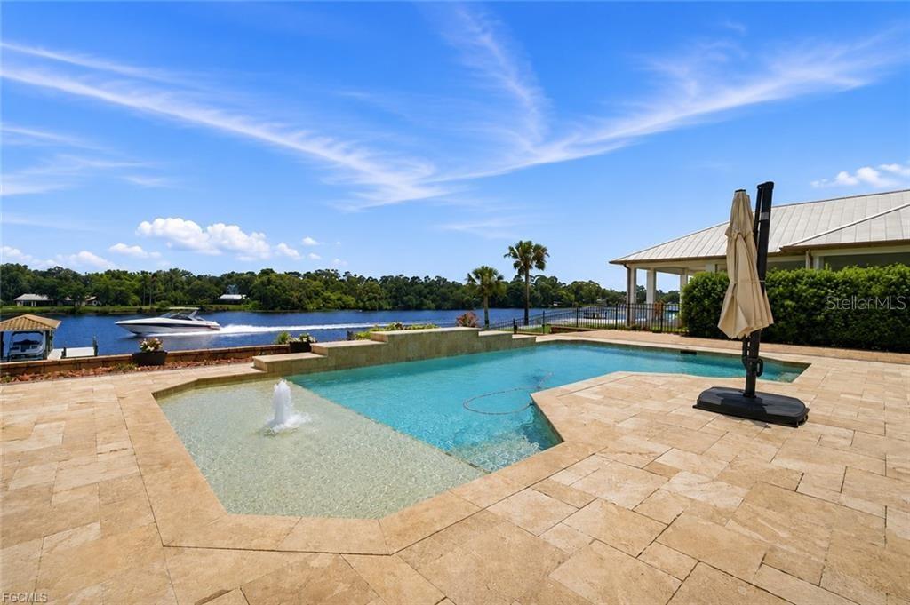 An aerial view of a house with a swimming pool and a fenced backyard — 2504 CALOOSA SHORES DRIVE, LABELLE, FL