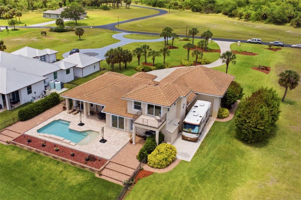 An aerial view of a single-story house with a tile roof and a waterfront backyard — 2504 CALOOSA SHORES DRIVE, LABELLE, FL