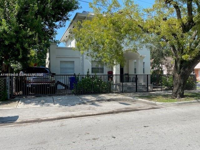 A two-story white house with a front porch stands behind a black metal fence — 876 SW 2nd St, Miami FL 33130, MIAMI, FL