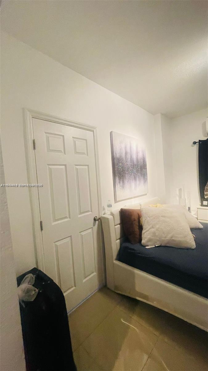 A bedroom features a white door, a bed with white and brown pillows, and wall art — 876 SW 2nd St, Miami FL 33130, MIAMI, FL