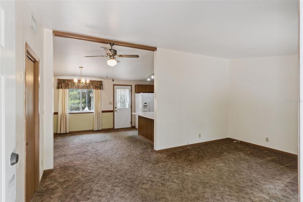 A carpeted living room opens into a kitchen and dining area with a ceiling fan — 3803 YOUNG ROAD, LAKE WALES, FL
