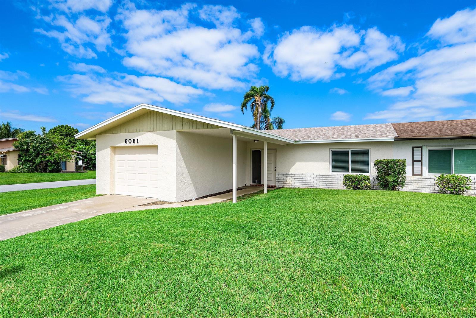 A single-story house with a white stucco exterior, a garage, and a green lawn — 6061 Stanley Lane, Delray Beach FL 33484, DELRAY BEACH, FL