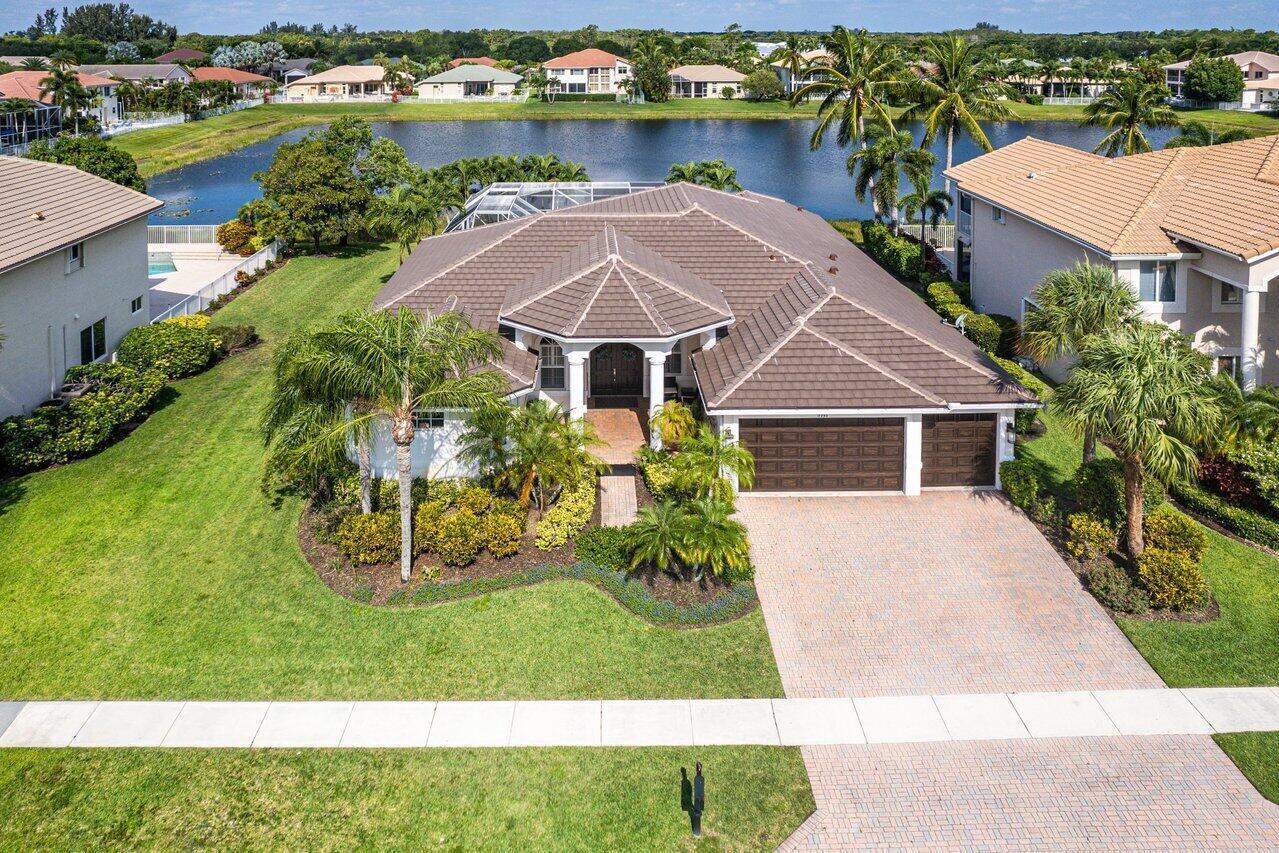 An aerial view of a single-story house with a brown tile roof and brick driveway — 11750 Osprey Pointe Circle, Wellington FL 33449, WELLINGTON, FL