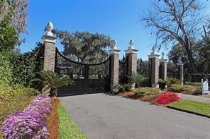 A paved driveway leads to a gated entrance with brick pillars and decorative finials — 28963 Grandview Manor, FL 32097, FL