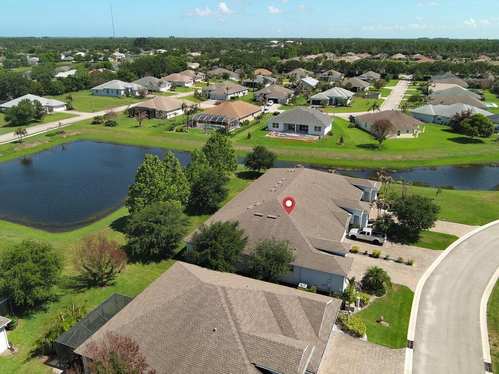 An aerial view shows a suburban neighborhood with houses, a pond, and a red pin — 6087 Scott Story Way, Vero Beach FL 32967, VERO BEACH, FL