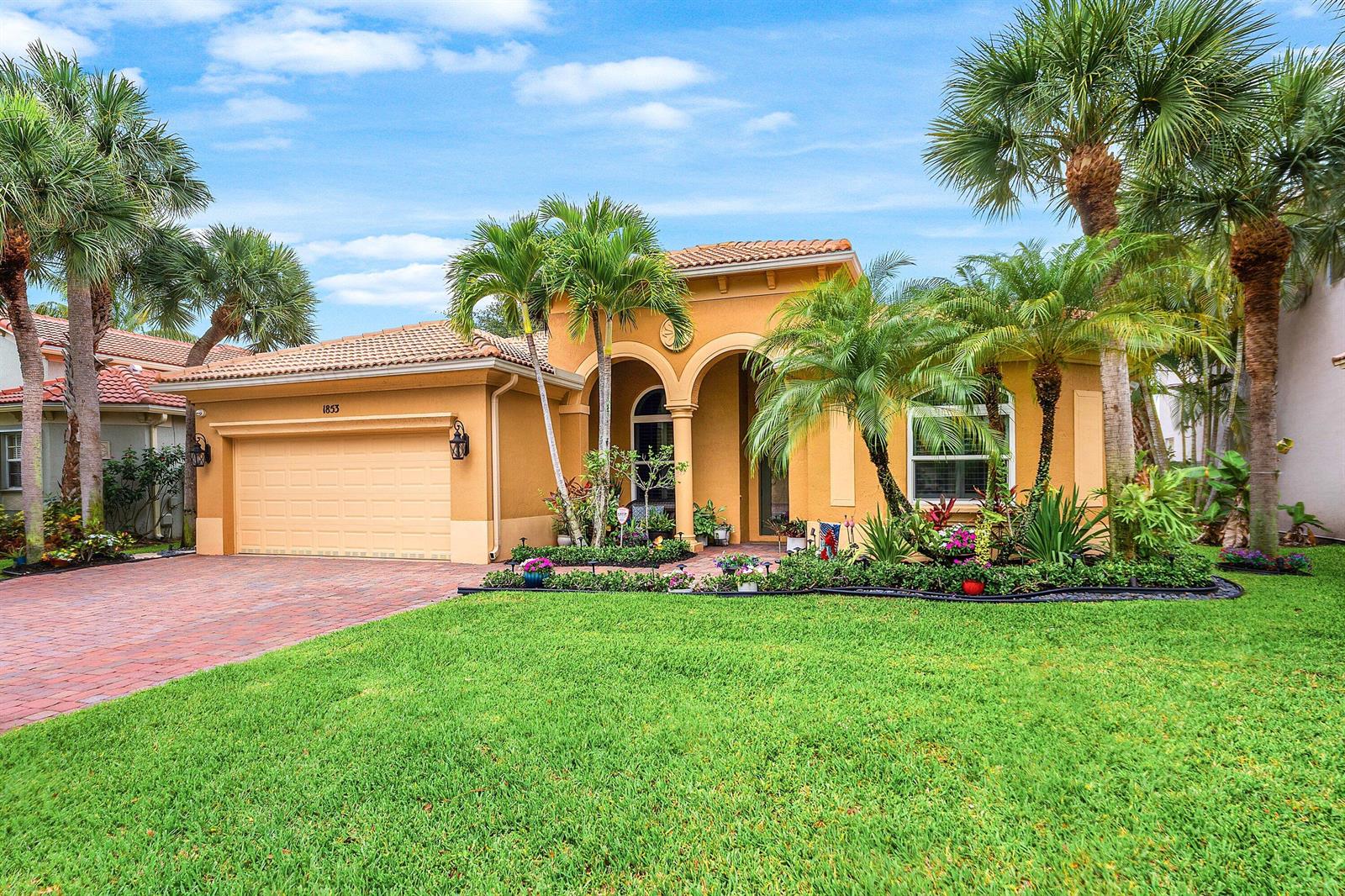 A single-story stucco house with a tile roof, two-car garage, and palm trees in front — 1853 Palisades Drive, West Palm Beach FL 33411, WEST PALM BEACH, FL