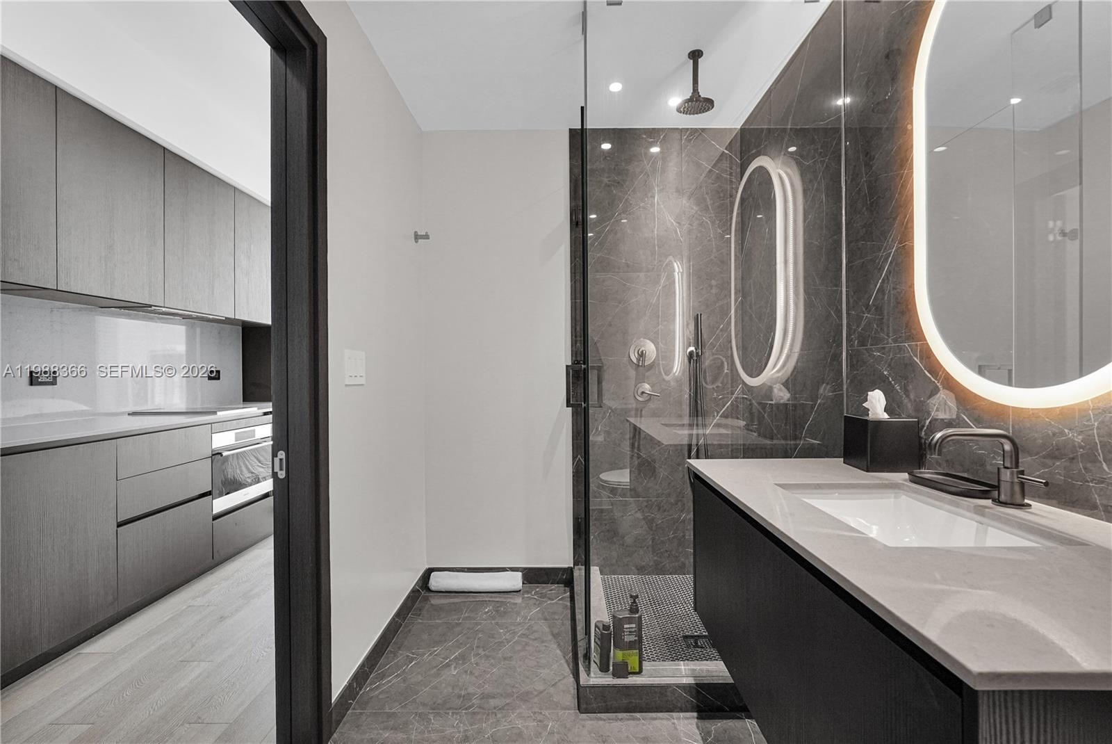 A modern bathroom features a glass-enclosed shower, dark marble tile, and a floating vanity — 20 NE 11th St # 3603A, Miami FL 33132, MIAMI, FL