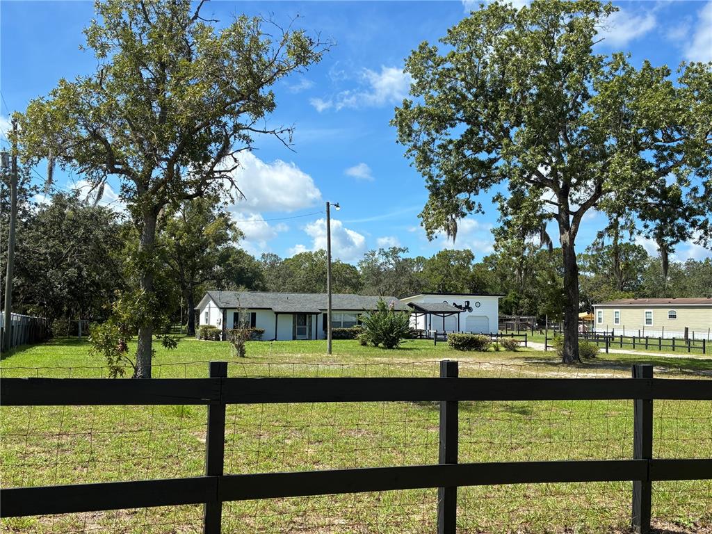 A single-story house with a white exterior, black trim, and a detached two-car garage — 17620 CHORVAT AVENUE, SPRING HILL, FL