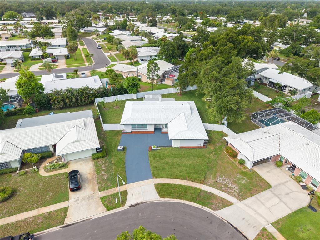 An aerial view of a single-story house with a white roof and a blue driveway — 2065 ENVOY COURT, CLEARWATER, FL