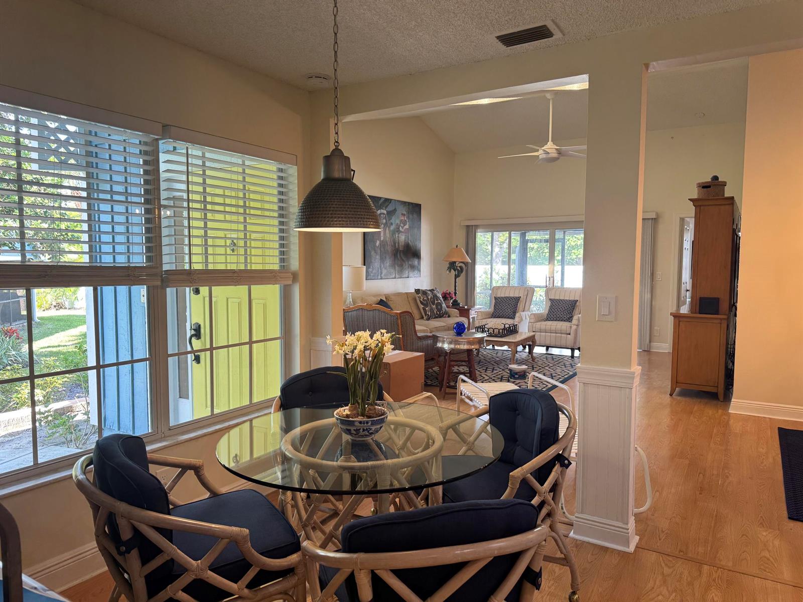 A dining area with a glass-topped rattan table overlooks a living room with vaulted ceilings — 108 Ocean Dunes Circle # 108, Jupiter FL 33477, JUPITER, FL