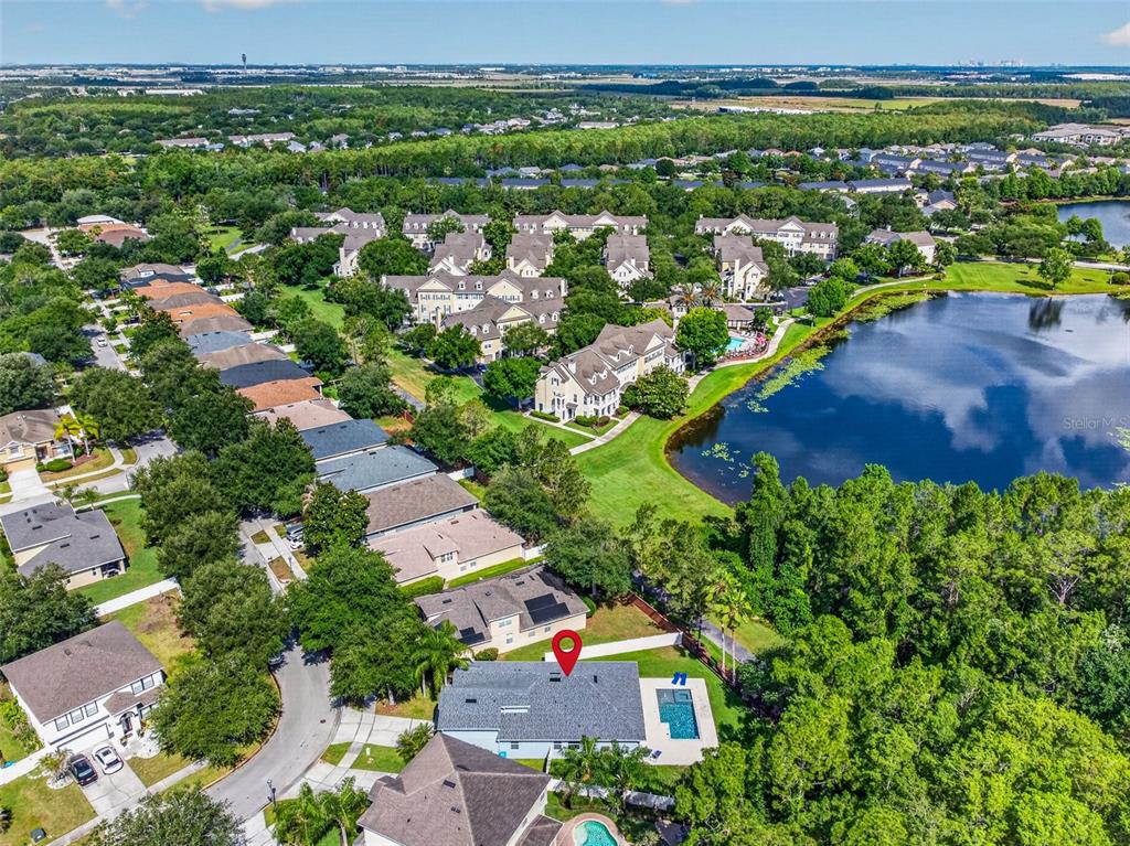 An aerial view shows a residential house with a pool and a nearby lake — 9669 LELAND DRIVE, ORLANDO, FL