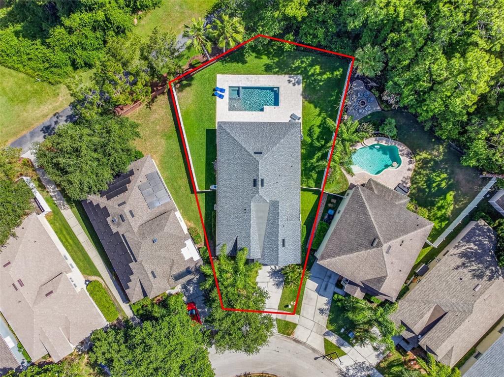 An aerial view shows a house with a pool and fenced backyard on a lot — 9669 LELAND DRIVE, ORLANDO, FL