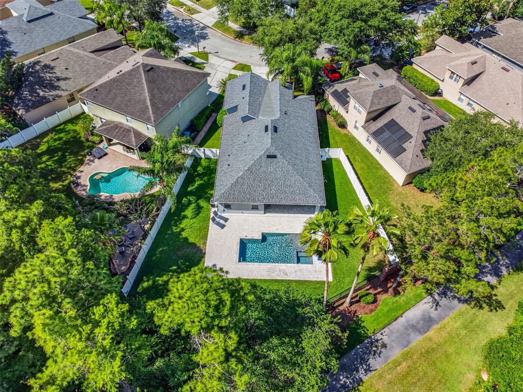 An aerial view shows a house with a backyard pool and patio in a neighborhood — 9669 LELAND DRIVE, ORLANDO, FL