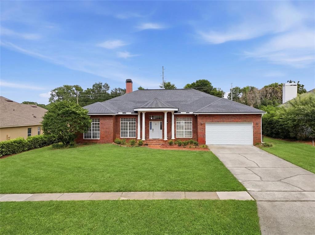 A single-story brick house with a white garage door and a covered front entryway — 9137 DOLLANGER COURT, ORLANDO, FL