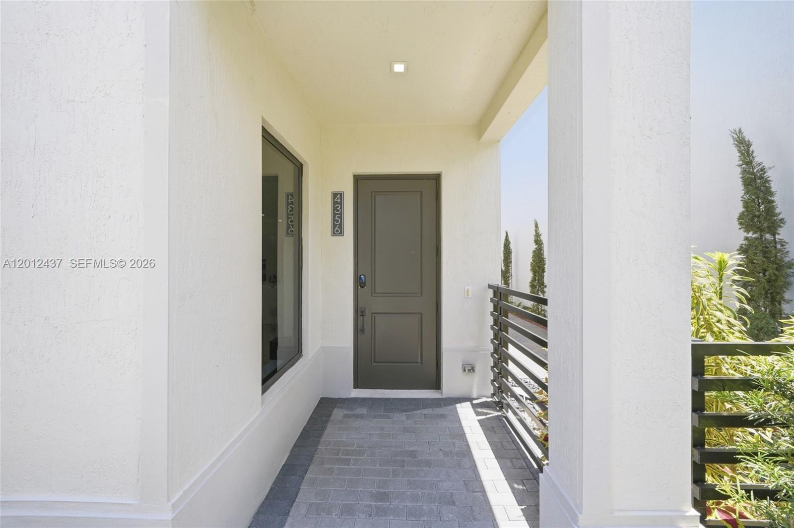 A covered entryway features a gray door, a large window, and gray paver flooring — 4356 NW 80th Ave, Doral FL 33166, DORAL, FL