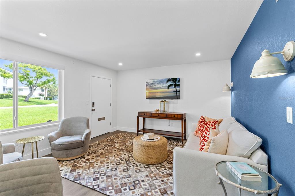 A living room features a blue accent wall, a patterned rug, and a white sofa — 1140 S ORLANDO AVENUE UNIT B-7, MAITLAND, FL