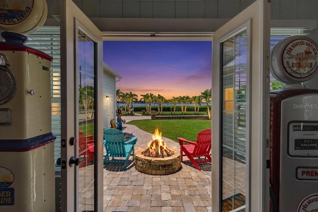 A view from a doorway looking out at a patio with a fire pit — 216 SUNRISE DRIVE, NOKOMIS, FL