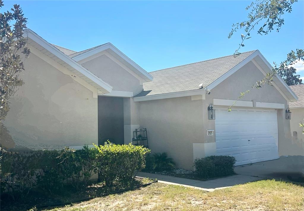A single-story house with a beige stucco exterior, a two-car garage, and a front entryway — 3921 SW 58TH AVENUE, OCALA, FL