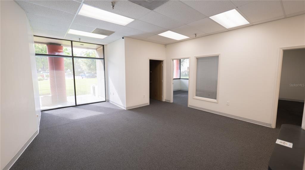 An empty office space features gray carpeting, white walls, drop ceilings, and large windows — 1209 TECH BOULEVARD UNIT 102/104, TAMPA, FL