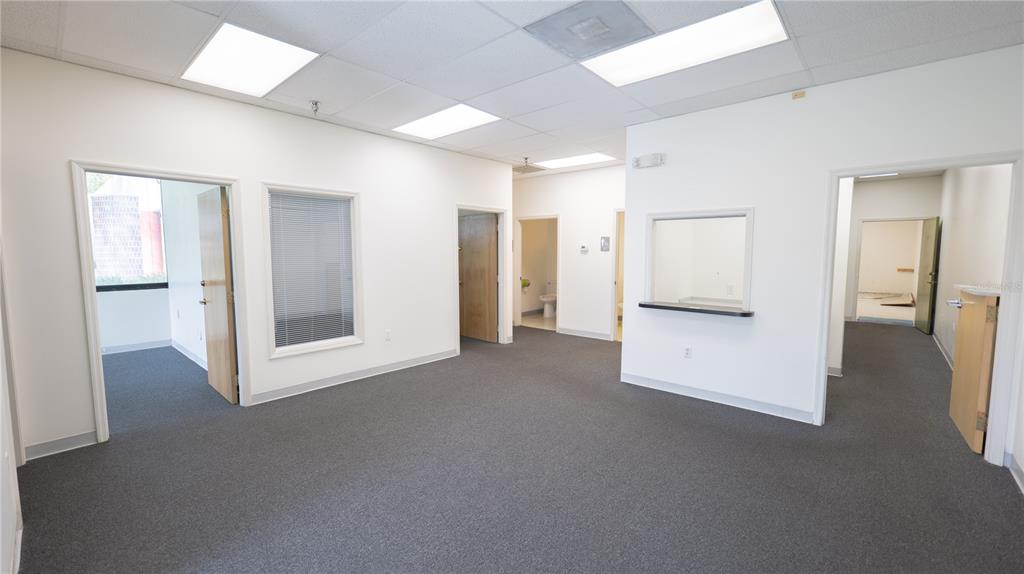 An empty office space with gray carpeting, white walls, drop ceilings, and multiple doorways — 1209 TECH BOULEVARD UNIT 102/104, TAMPA, FL