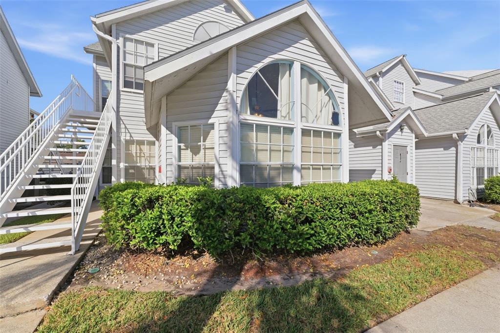 Exterior view of a multi-story residential building with white siding and an outdoor staircase — 12245 ARMENIA GABLES CIRCLE UNIT 12245, TAMPA, FL