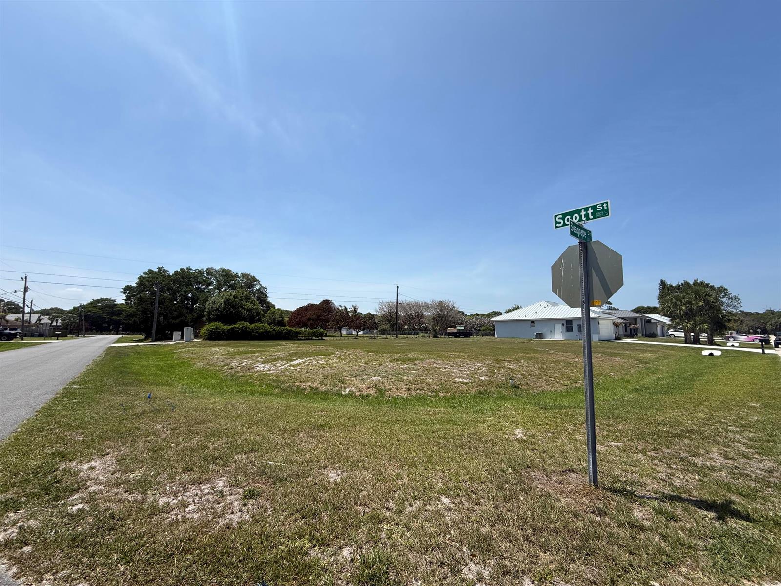 A vacant, grassy corner lot features a street sign and a stop sign — Tbd Seagrape Drive, Fort Pierce FL 34982, FORT PIERCE, FL