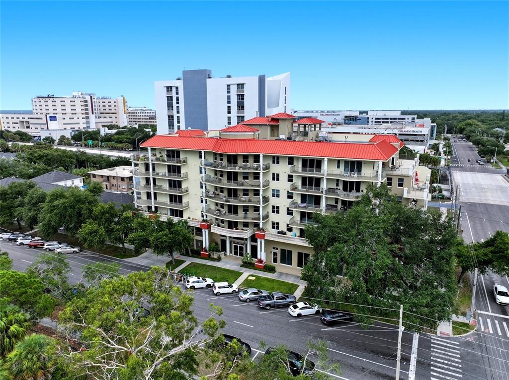 An aerial view of a multi-story apartment building with a red roof and balconies — 750 4TH AVENUE S UNIT 705D, ST PETERSBURG, FL