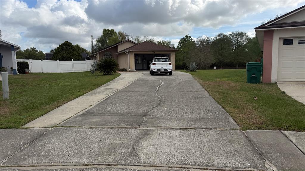 A single-story house with a concrete driveway and a white car parked in the garage — 632 DHARMA CIRCLE, WINTER GARDEN, FL