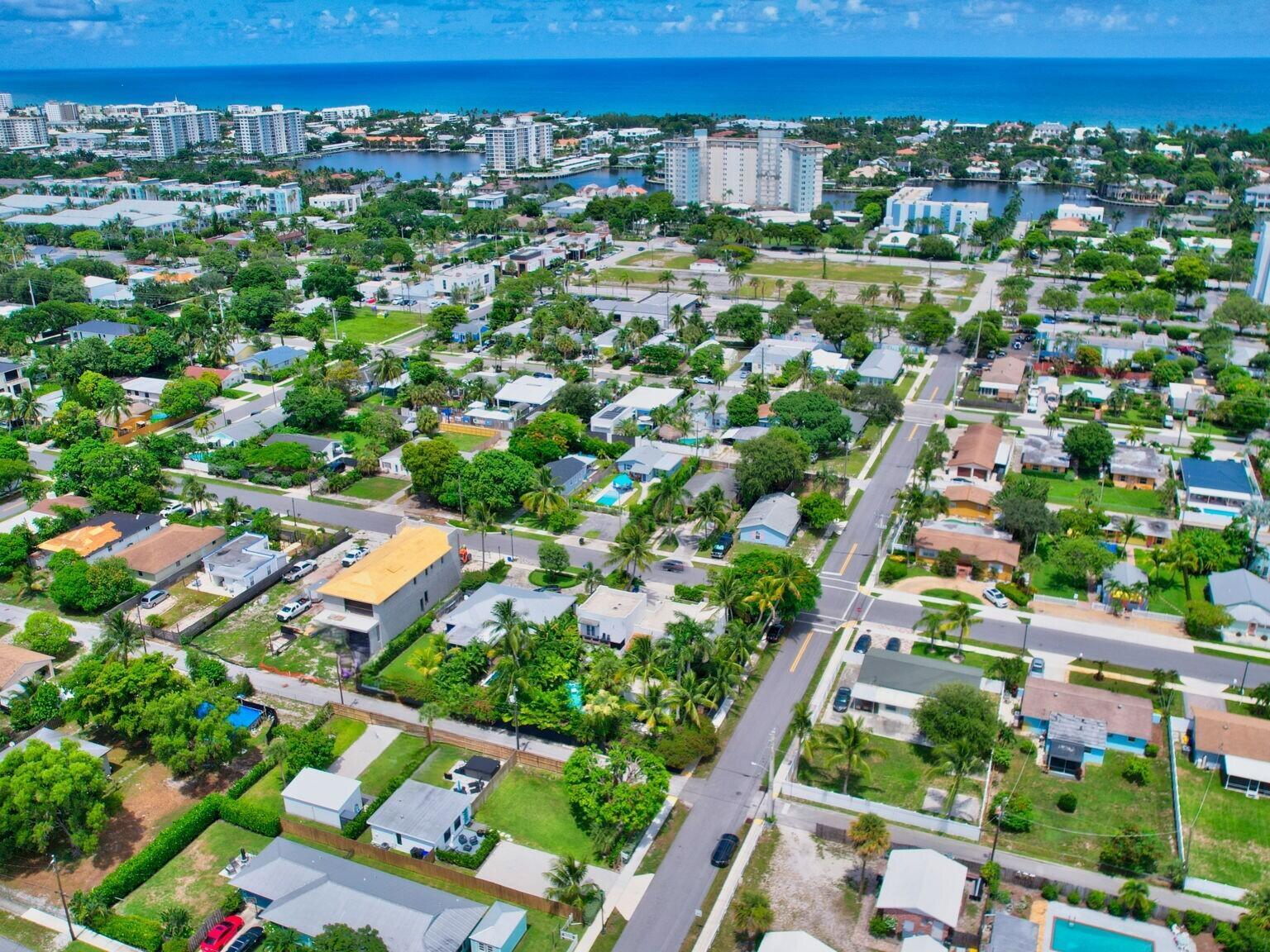 An aerial view of a residential neighborhood with houses, palm trees, and a distant ocean — 201 SE 7th Street, Delray Beach FL 33483, DELRAY BEACH, FL