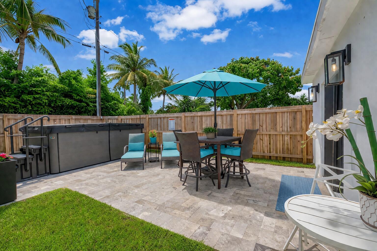 A patio features a hot tub, dining set with a blue umbrella, and lounge chairs — 201 SE 7th Street, Delray Beach FL 33483, DELRAY BEACH, FL