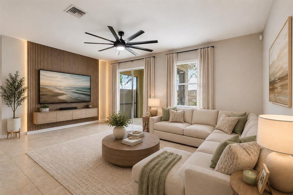 A modern living room features a slatted wood accent wall, sectional sofa, and ceiling fan — 18843 ULMUS STREET, LUTZ, FL