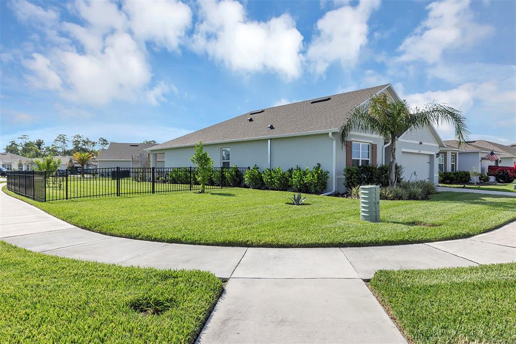 A single-story house with a fenced yard, green lawn, and a concrete sidewalk — 3221 SILAS DRIVE, NEW SMYRNA BEACH, FL