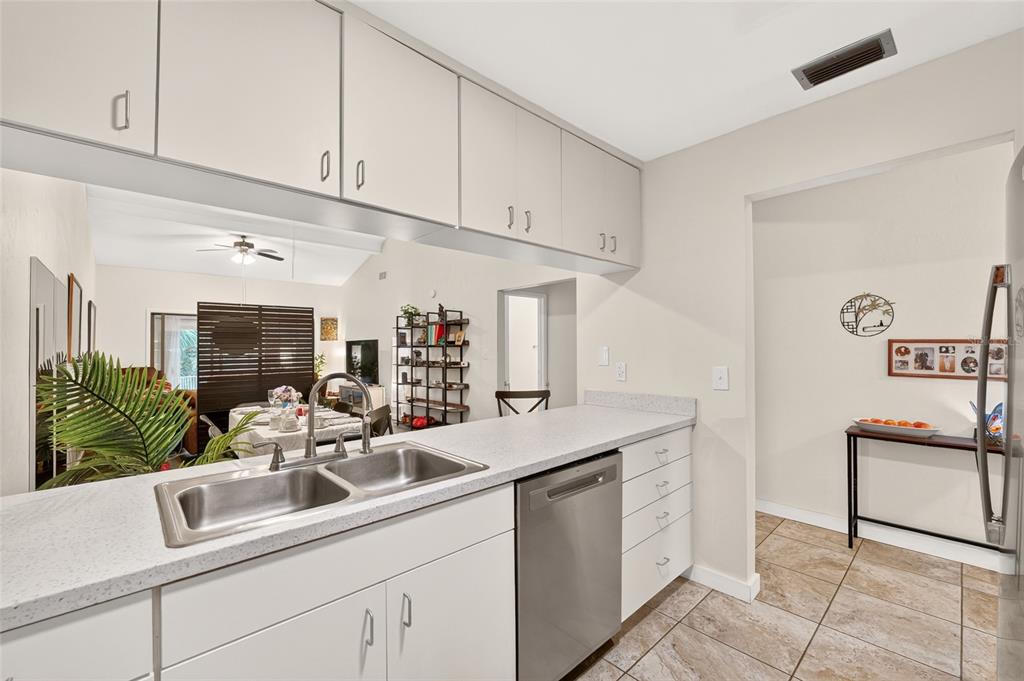 A kitchen with white cabinets, a stainless steel dishwasher, and a double-basin sink — 11413 NW 67TH TERRACE, ALACHUA, FL