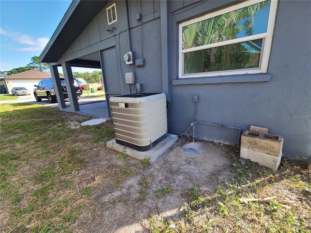 An exterior view of a house showing an HVAC unit on a concrete pad — 8271 PELICAN ROAD, ENGLEWOOD, FL