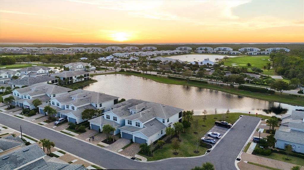 An aerial view shows a residential neighborhood with multi-family homes surrounding a central lake — 14655 SYCAMORE COURT UNIT 3121, PUNTA GORDA, FL